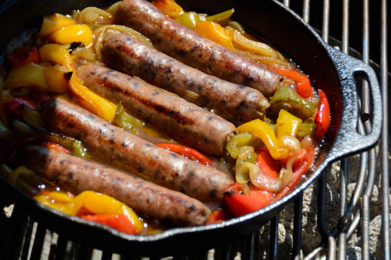 Beer Brats garen in der Feuerpfanne vor sich hin