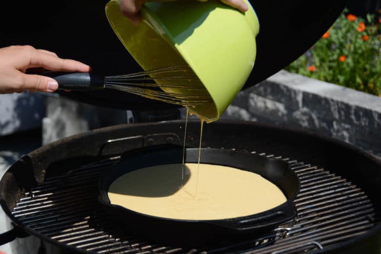 Den Teig für den Kaiserschmarren in die Feuerpfanne leeren