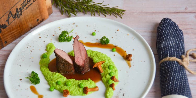 Zarter rosa gegrillter Rehrücken auf Erbsenpüree