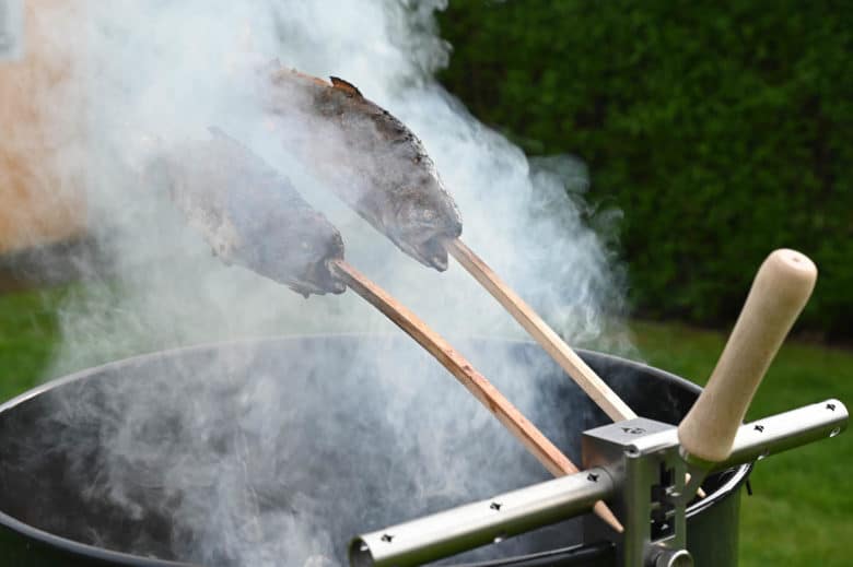 Der finale Abschluss des Steckerlfisch über dem Feuer